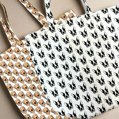 Two eco-friendly tote bags by House of Woof featuring hand-drawn dog breed patterns — Golden Retriever and Boston Terrier designs.
