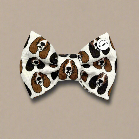 Hand-drawn Basset Hound dog bow tie from House of Woof, featuring long-eared brown and black hounds on a white background.