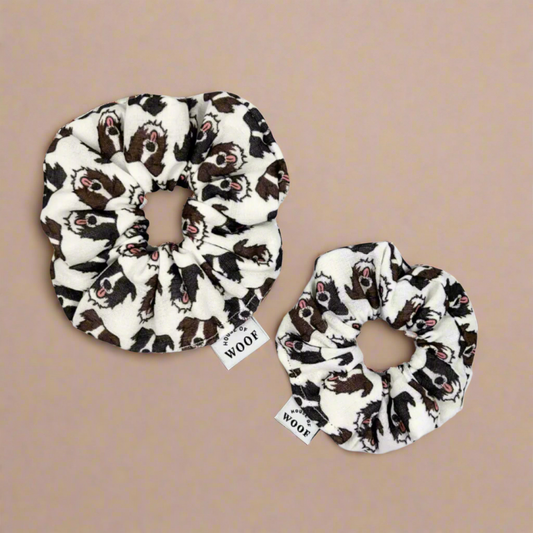 Two House of Woof fabric scrunchies featuring a Border Collie dog print, displayed on a warm beige background.