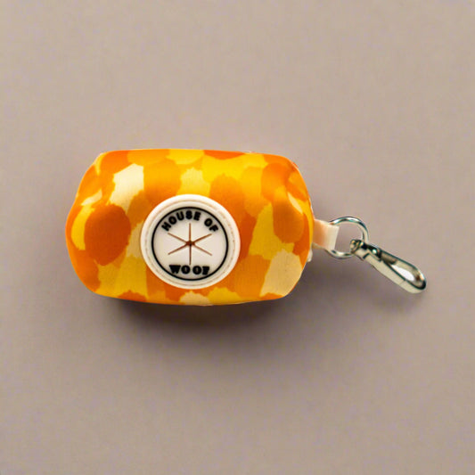 Orange dog poo bag holder with 'House of Woof' logo on a beige background